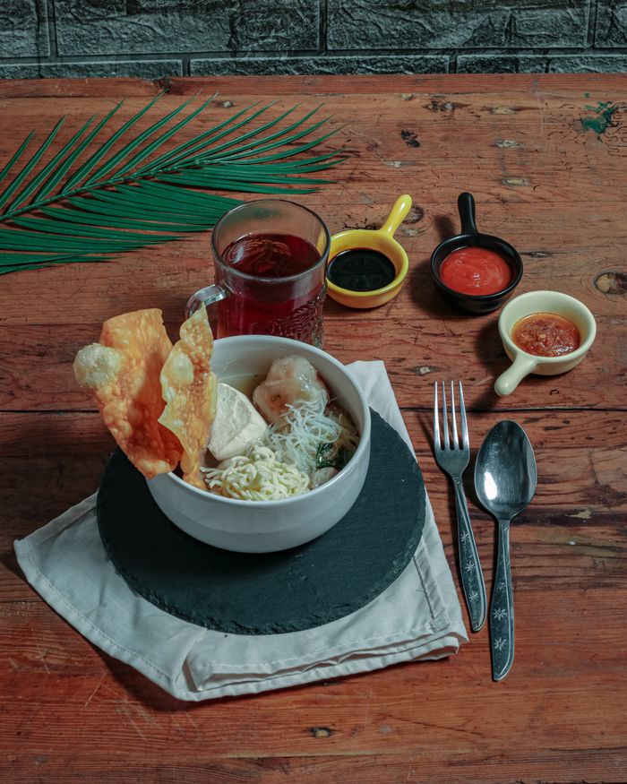 services-03 Delicious bowl of Mie Ayam with wontons and sides, perfect for Indonesian culinary exploration.