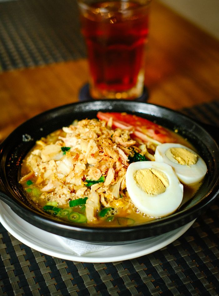 Mastering the First Impression: Your intriguing post title goes here Savory Indonesian noodle soup topped with chicken, fried shallots, boiled egg, and herbs.